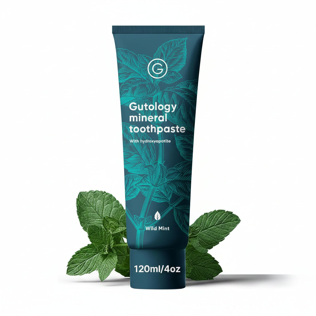 Gutology mineral toothpaste tube with mint leaves on a white background